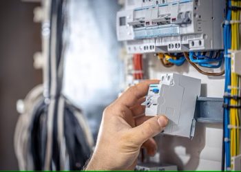 male-electrician-works-switchboard-with-electrical-connecting-cable_169016-16570